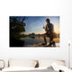 Young man fishing at misty sunrise Wall Mural