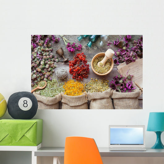 Healing herbs in hessian bags, wooden mortar, small bottles on o Wall Mural