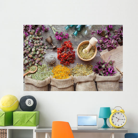 Healing herbs in hessian bags, wooden mortar, small bottles on o Wall Mural