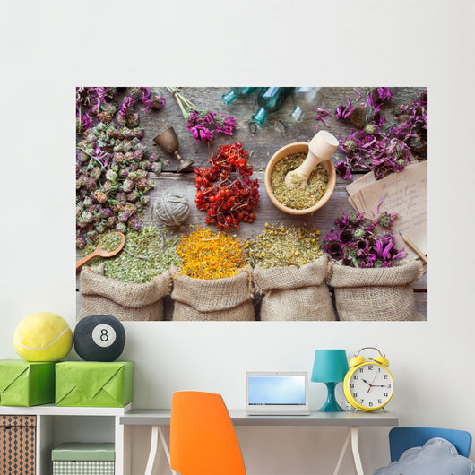 Healing herbs in hessian bags, wooden mortar, small bottles on o Wall Mural