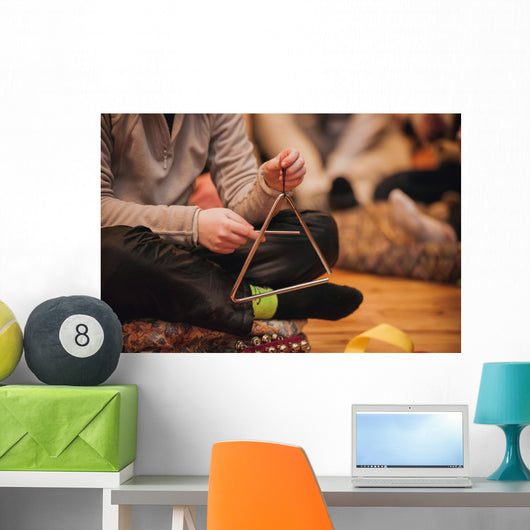 girl playing a musical triangle Wall Mural
