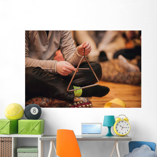 girl playing a musical triangle Wall Mural