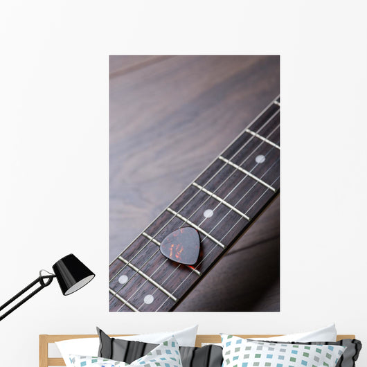 Guitar frets with strings and mediator on dark brown surface Wall Mural