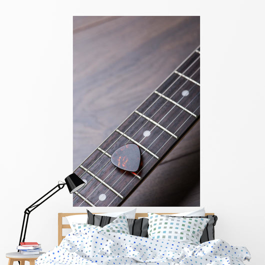 Guitar frets with strings and mediator on dark brown surface Wall Mural