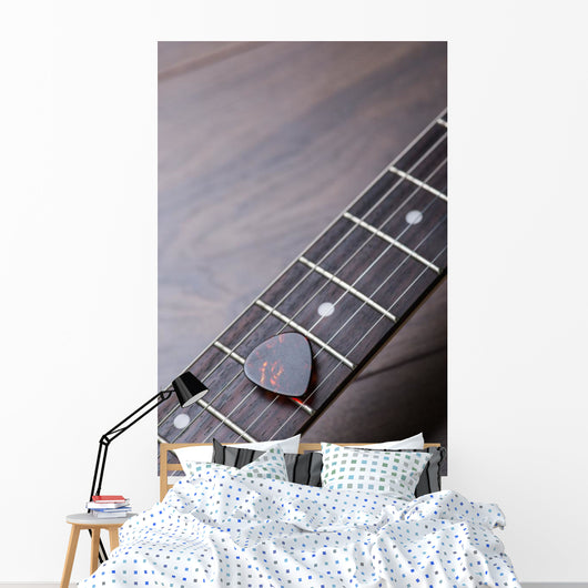 Guitar frets with strings and mediator on dark brown surface Wall Mural