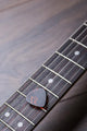 Guitar Frets With Strings And Mediator On Dark Brown Surface Wall Decal