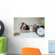 Man sleeps in office on table over laptop with coffee in hand Wall Mural