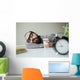 Man sleeps in office on table over laptop with coffee in hand Wall Mural