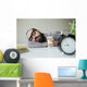 Man sleeps in office on table over laptop with coffee in hand Wall Mural