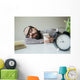 Man sleeps in office on table over laptop with coffee in hand Wall Mural