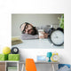Man sleeps in office on table over laptop with coffee in hand Wall Mural