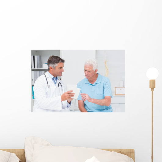 Doctor explaining prescription to senior patient Wall Mural
