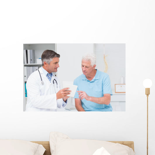 Doctor explaining prescription to senior patient Wall Mural