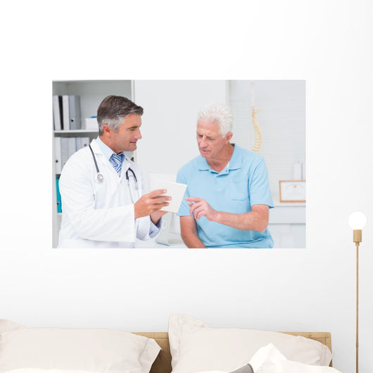 Doctor explaining prescription to senior patient Wall Mural