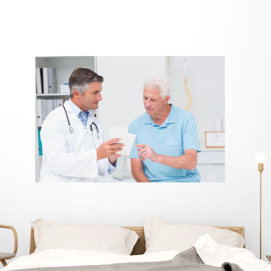 Doctor explaining prescription to senior patient Wall Mural