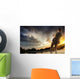 Young man fishing at dramatic sunset Wall Mural
