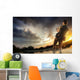 Young man fishing at dramatic sunset Wall Mural