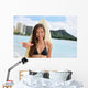 Surfer girl surfing showing mahalo shaka hand sign Wall Mural