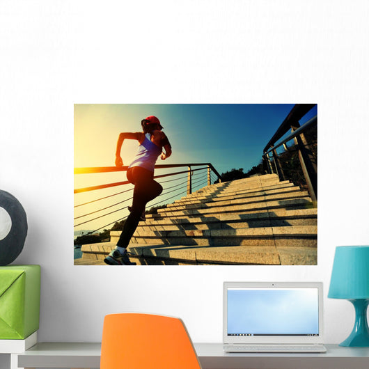 young fitness woman running on seaside stone stairs Wall Mural