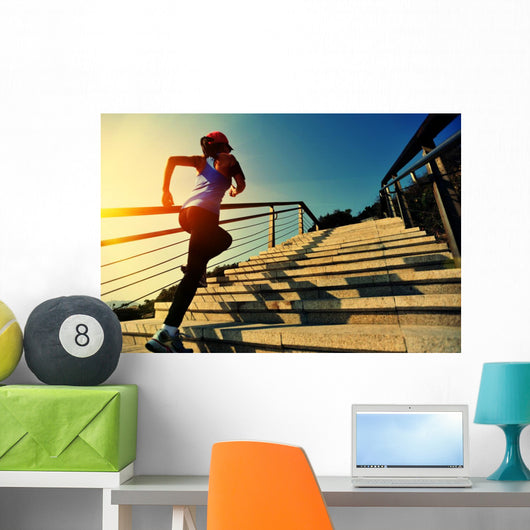 young fitness woman running on seaside stone stairs Wall Mural