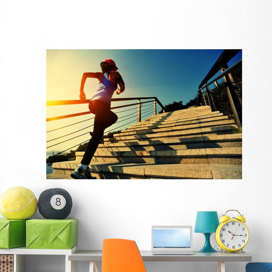 young fitness woman running on seaside stone stairs Wall Mural