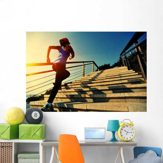 young fitness woman running on seaside stone stairs Wall Mural