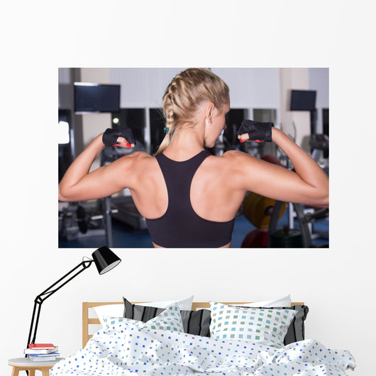 Strong woman shows her muscles Wall Mural