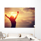 cheering woman open arms at sunrise seaside Wall Mural