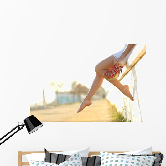 Woman legs silhouette with heels hanging of her hands Wall Mural