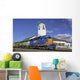 Train engine pulls its cars by the depot with blue sky Wall Mural