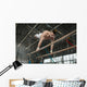 Athlete topless doing exercises on the uneven bars Wall Mural