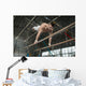 Athlete topless doing exercises on the uneven bars Wall Mural
