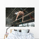 Athlete topless doing exercises on the uneven bars Wall Mural