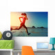 young woman running on sunrise beach  Wall Mural