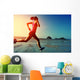 young woman running on sunrise beach  Wall Mural