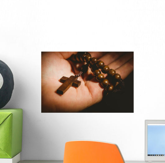Hand holding wooden rosary beads Wall Mural