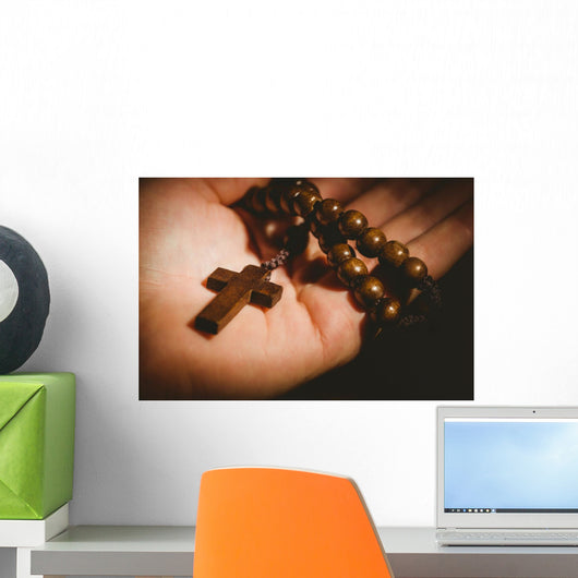 Hand holding wooden rosary beads Wall Mural