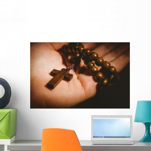 Hand holding wooden rosary beads Wall Mural