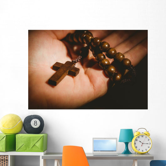 Hand holding wooden rosary beads Wall Mural