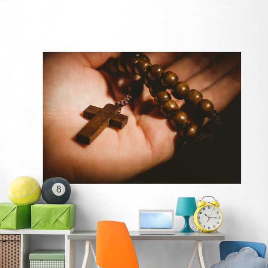 Hand holding wooden rosary beads Wall Mural