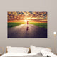 Happy woman jumping on long straight road, way towards sun Wall Mural