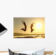 Fitness couple jumping happy at sunset Wall Mural