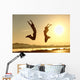 Fitness couple jumping happy at sunset Wall Mural