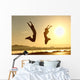 Fitness couple jumping happy at sunset Wall Mural
