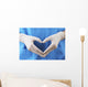 Doctor showing shape of heart by his hands in sterile gloves, Wall Mural