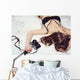 Pretty girl lying on the bed in bra with a camera Wall Mural