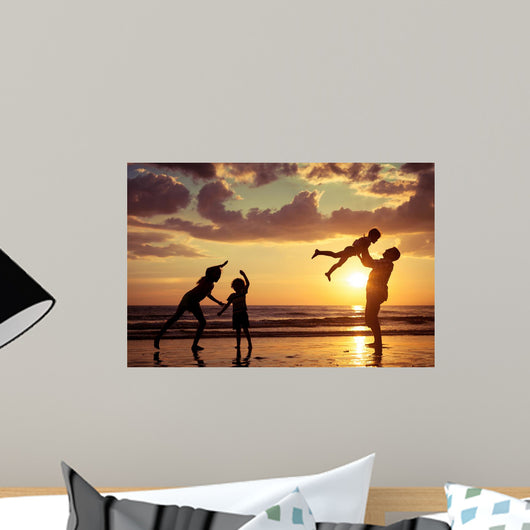 Father and children playing on the beach Wall Mural