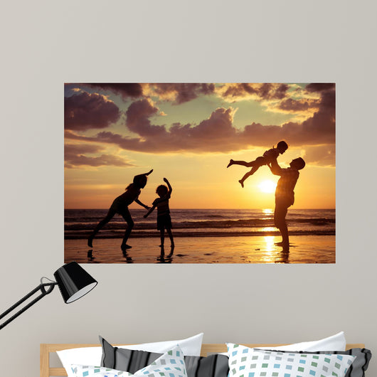 Father and children playing on the beach Wall Mural