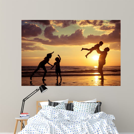 Father and children playing on the beach Wall Mural