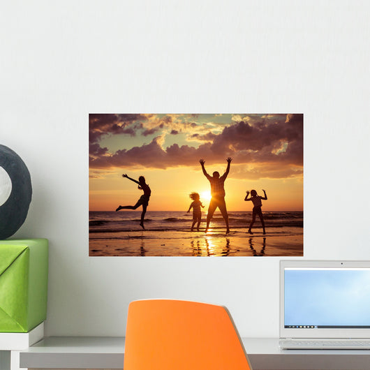 Father and children playing on the beach Wall Mural
